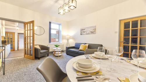sala de estar con mesa y sofá en Host & Stay - Millbank Crescent Apartments en Bedlington