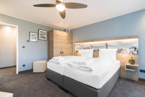 ニュルンベルクにあるAparthotel by dasPaulの大きな窓のある大きな白いベッドのある寝室