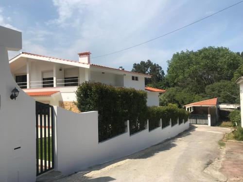 a white fence in front of a house at Farm stay in Maceira, Leiria 