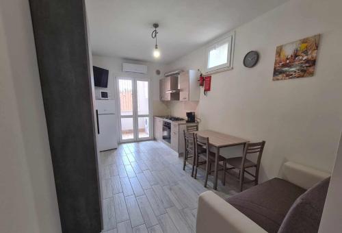 una cucina e una sala da pranzo con tavolo e sedie di Civico 14 Apartment 01 a Monserrato