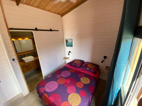 um pequeno quarto com uma cama num quarto em La Case Savane em Saint-Leu