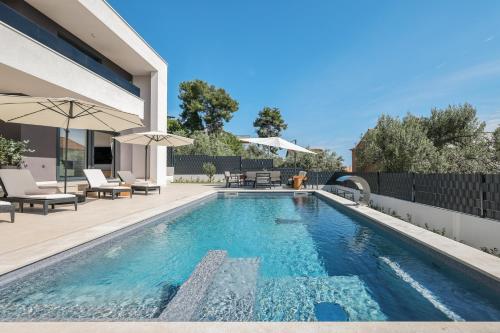 una piscina en el patio trasero de una casa en Villa Dekorti - Adriatic Luxury Villas, en Kožino