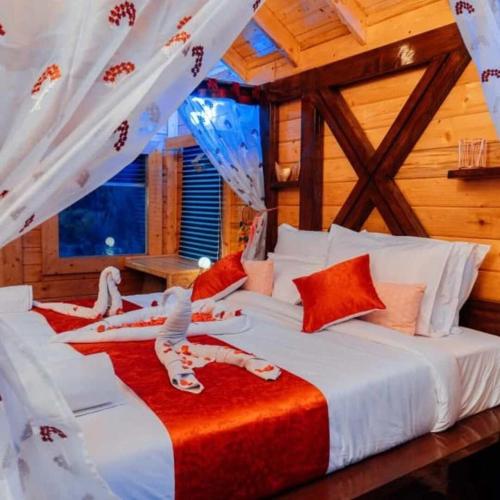 een slaapkamer met 2 bedden met witte en rode lakens bij DSR Wooden Cottages in Hyderabad