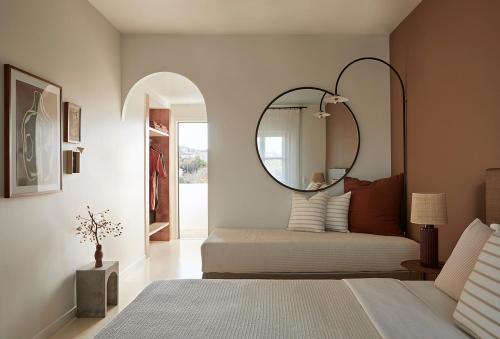a bedroom with a bed with a mirror on the wall at Yayaki Spetses in Spetses