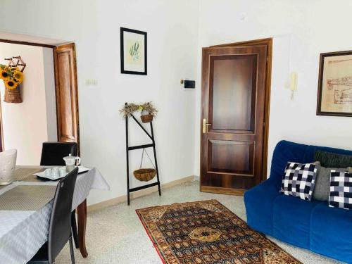 a living room with a blue couch and a wooden door at “La Lavanda” in Maremma in Ischia di Castro