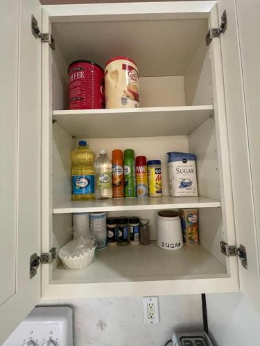 a cabinet filled with lots of food and drinks at Pool Home in Englewood