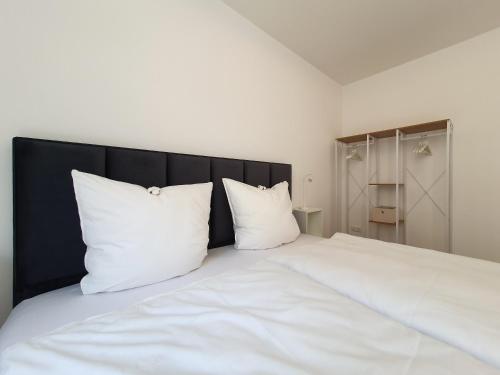 a large white bed with two pillows on it at Ferienwohnungen am Theater - modern, zentral und ruhig mit Küche, Waschtrockner, Netflix, Wlan und Parkplatz- 2 Zimmer, 52 qm in Cottbus