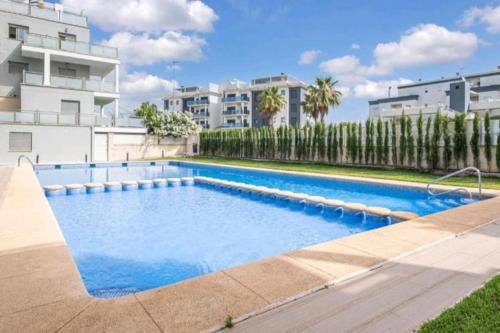 a swimming pool in front of a building at Moderno apartamento en Oliva Nova golf & MET in Oliva