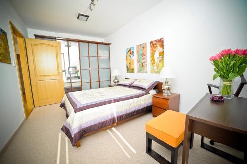 格地尼亞的住宿－豪華洛克菲勒海洋大廈公寓，一间卧室配有一张床、一张书桌和一张书桌