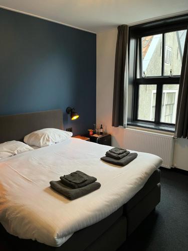 1 dormitorio con 1 cama con 2 toallas en Hotel Grandcafe De Doelen, en Franeker