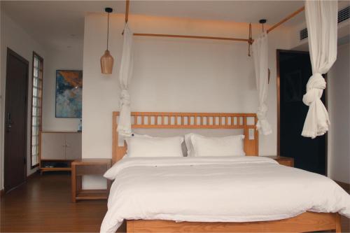 a bedroom with a large white bed with white pillows at 张家界天门山伴田居民宿 in Zhangjiajie