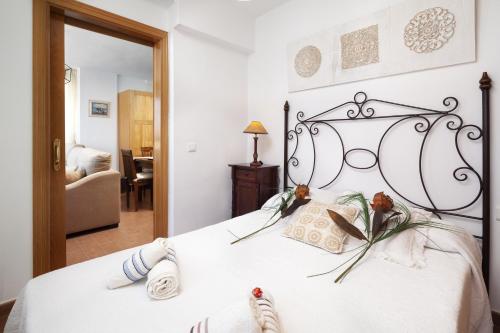 a bedroom with a white bed with two pillows at Las Terrazas Primera Línea de playa in Mezquitilla