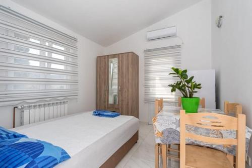 a bedroom with a bed and a table with a plant at Apartmani Bar in Bar