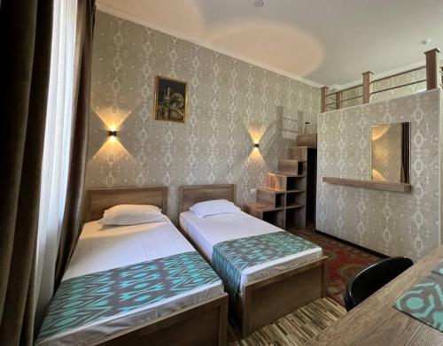 - 2 lits dans une petite chambre avec une table dans l'établissement Zahid Inn, à Tachkent