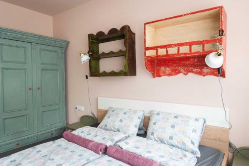 許邁格的住宿－Bökény-vendégház，一间卧室配有一张床和一个绿色的橱柜