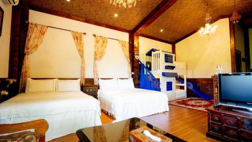 a bedroom with two beds and a flat screen tv at Xin Yuan My Dream Castle in Dongshan