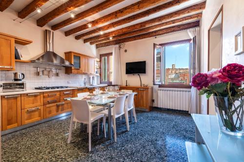 a kitchen with a table and chairs and a tv at Al Campanile View and Terrace in Venice