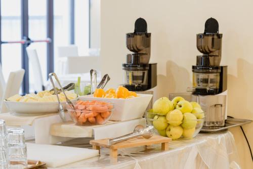 a table topped with bowls of fruits and vegetables at Hotel Calabona in Alghero