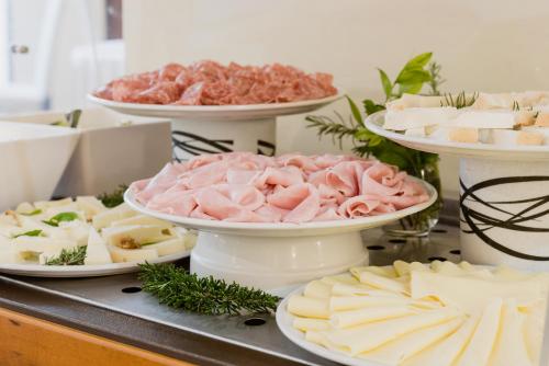 a table topped with plates of cheese and meats at Hotel Calabona in Alghero