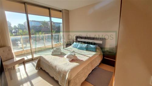 a bedroom with a bed and a large window at Apartamento T2 Salgados in Albufeira