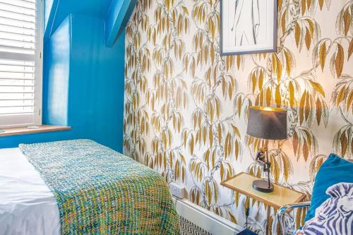 Minchinhampton的住宿－Maple Rose - 2 Bed with Garden in Minchinhampton!，一间卧室配有一张床和一张带台灯的桌子