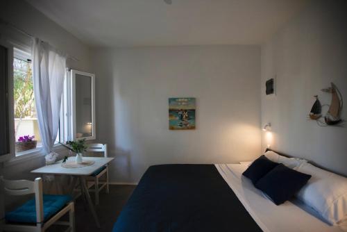 a bedroom with a bed and a table and a window at Skypiea Room in Agia Anna Naxos
