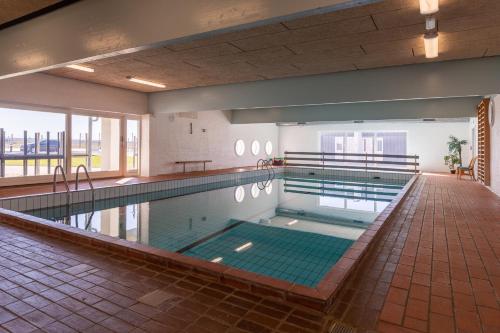 a large indoor swimming pool with a tile floor at Agger Holidays in Vestervig