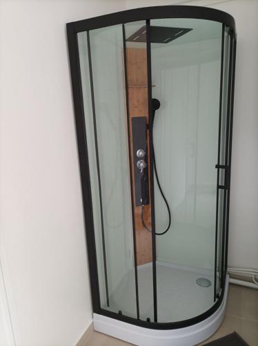 une douche avec une porte vitrée dans une salle de bain dans l'établissement O'Couvent - Appartement 66 m2 - 2 chambres - A523, à Salins-les-Bains