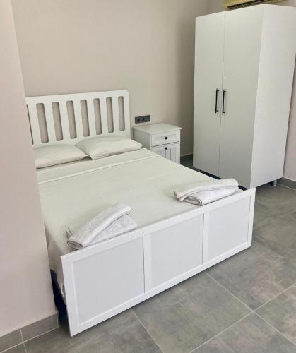 a bedroom with a large white bed and a white cabinet at La Sorella in Dalyan