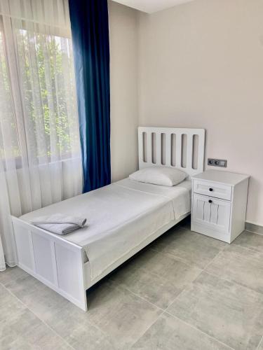 a bedroom with a white bed and a window at La Sorella in Dalyan