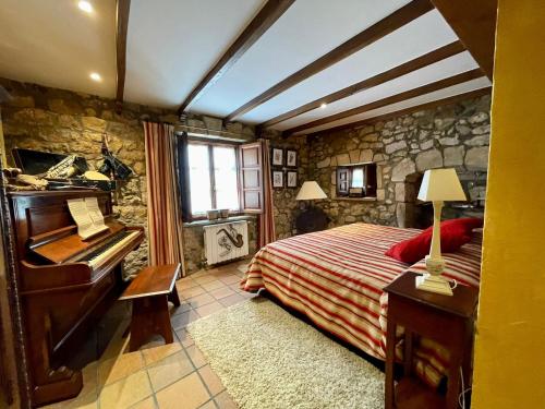 ein Schlafzimmer mit einem Bett und einem Klavier in der Unterkunft El palacio de Liaño pool chillout bbq in Liaño