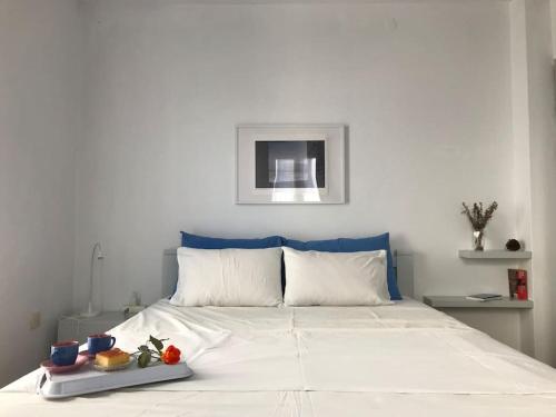 a white bed with a tray of food on it at VINTAGE HOUSE (4min from the port on foot) in Skopelos Town