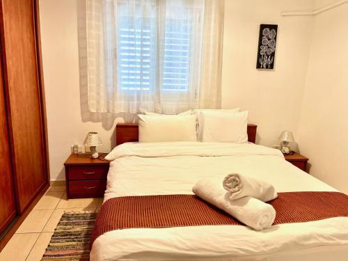 a bedroom with a large bed with a towel on it at Nomi Suites Marina Herzelia in Herzelia 
