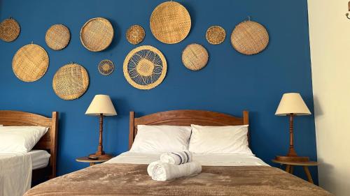 um quarto com uma parede azul e uma cama em Pousada Mawe em Paraty
