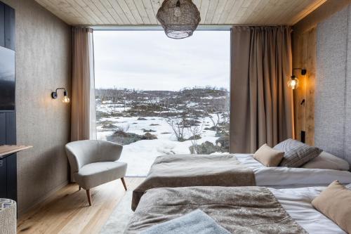 a bedroom with two beds and a large window at Santa's Hotel Rakka in Kilpisjärvi