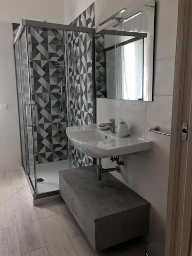 een badkamer met een wastafel en een douche met een spiegel bij Casa Estiva Francesco e Nicolò in Vieste