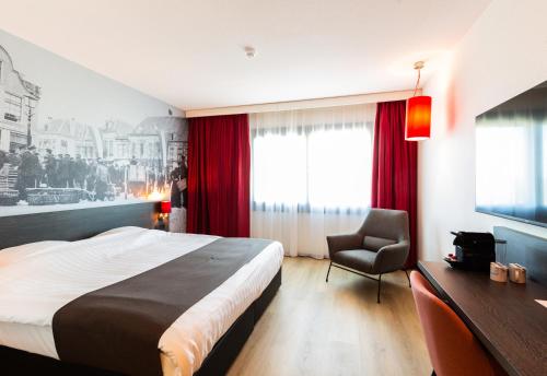 um quarto de hotel com uma cama e uma cadeira em Bastion Hotel Amersfoort em Amersfoort