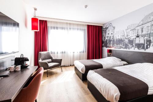 a hotel room with two beds and a desk at Bastion Hotel Amersfoort in Amersfoort