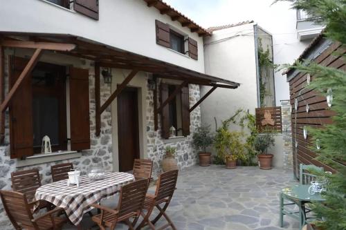 a patio with a table and chairs and a building at Two-storey house with loft at Agria,Volos in Agria