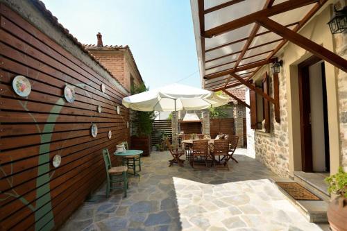 an outdoor patio with a table and an umbrella at Two-storey house with loft at Agria,Volos in Agria