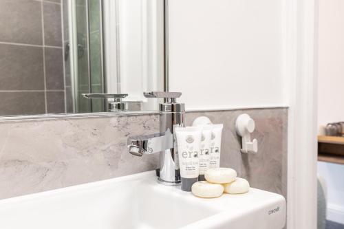 ein Badezimmer mit einem Waschbecken und zwei Handtüchern darauf in der Unterkunft The Chapter - Griffin House Hotel in London
