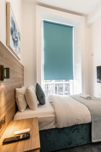 a bedroom with a bed and a large window at The Chapter Hotels - Griffin House in London