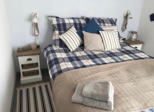 1 dormitorio con 1 cama con almohadas azules y blancas en Apartament 5 mórz, en Sianożęty