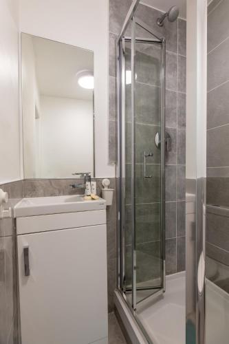 a bathroom with a shower and a sink at The Chapter Hotels - Griffin House in London