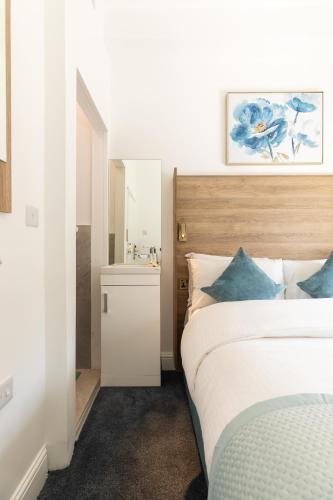 a bedroom with a bed and a sink and a mirror at The Chapter Hotels - Griffin House in London