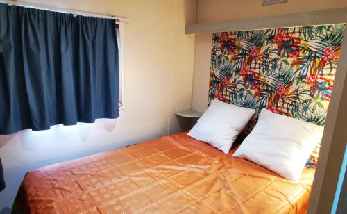 a bedroom with a bed with two pillows and a window at ATLANDES - Entre lac et mer in Biscarrosse