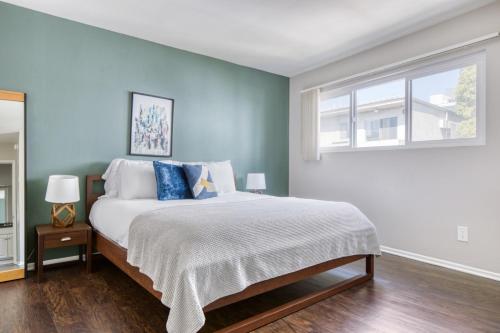 a bedroom with a bed with blue walls and a window at Westwood 1BR w Rooftop nr Westwood Village LAX-111 in Los Angeles