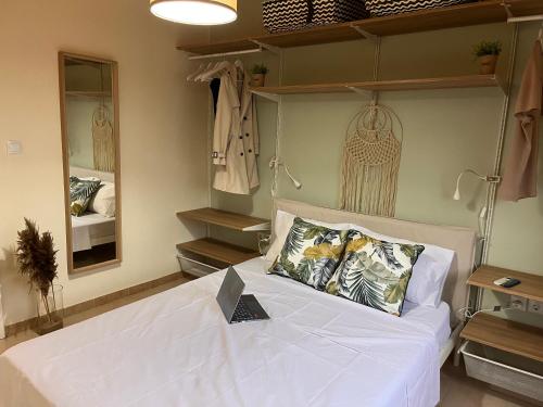 1 dormitorio con 1 cama con sábanas blancas y espejos en Niko Summer House, en Sozopoli