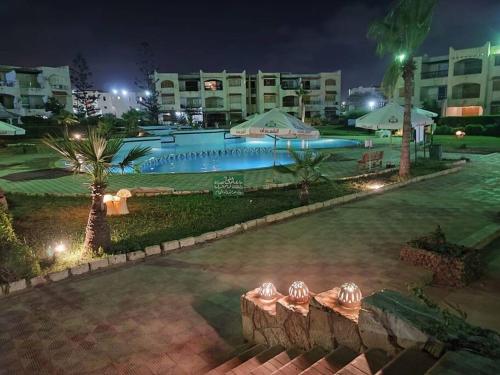 una piscina en un complejo por la noche en Spacious 3 bedroom apartment with a sea view., en Dawwār Abū Maḩrūs
