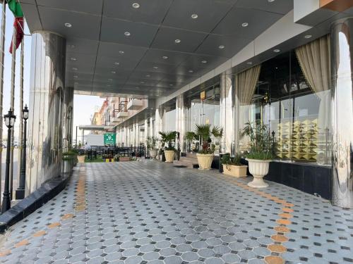 an empty hallway of a building with potted plants at فندق اليمامه الفندقية in Al Nairyah